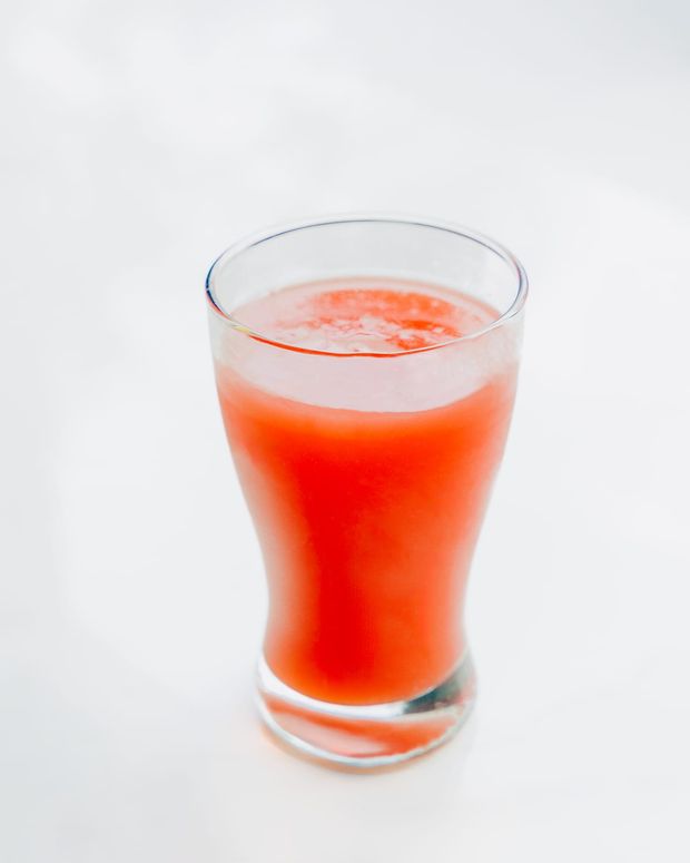 A tall glass of freshly pressed watermelon juice with a light foam