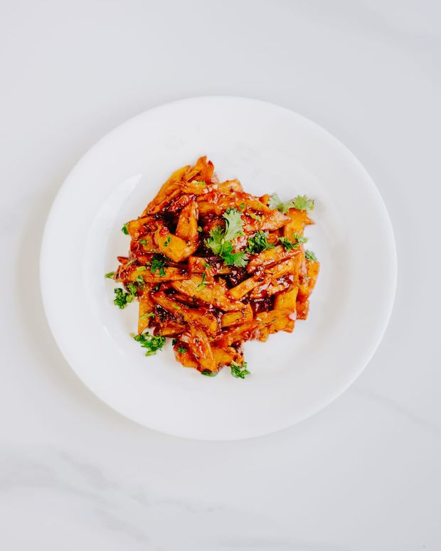 Thick-cut chips tossed in a glossy red masala sauce and scattered with fresh coriander