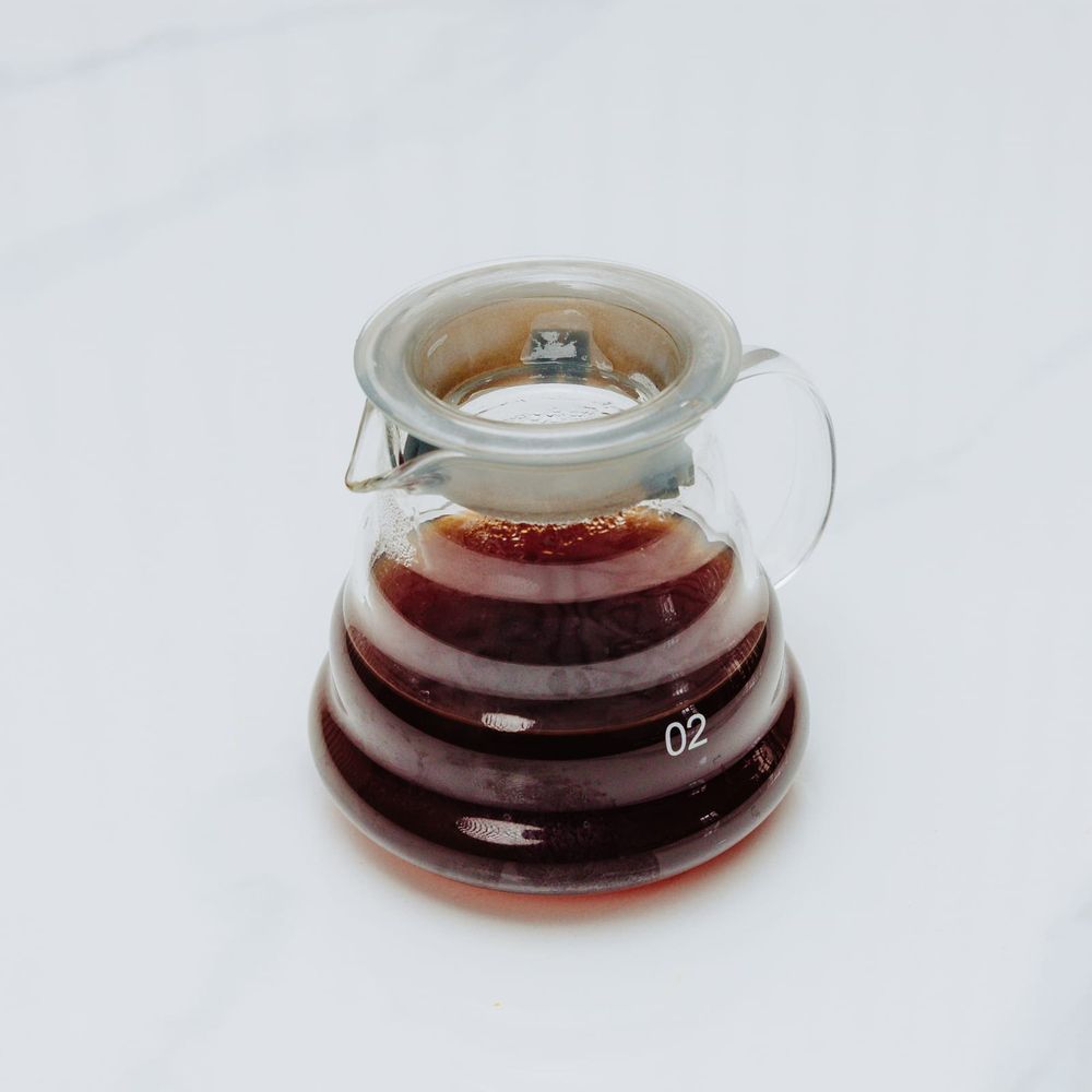 A Hario V60 glass server holding a fresh single-origin pour-over