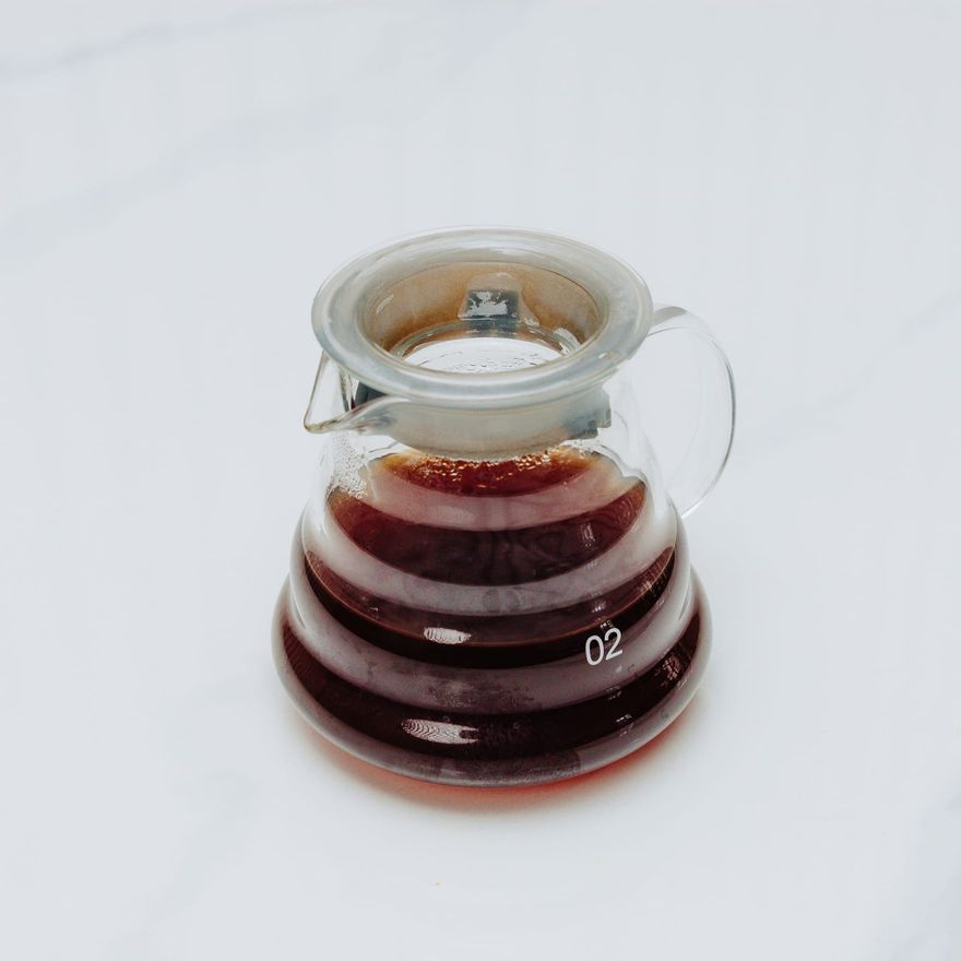 A Hario V60 glass server holding a fresh single-origin pour-over