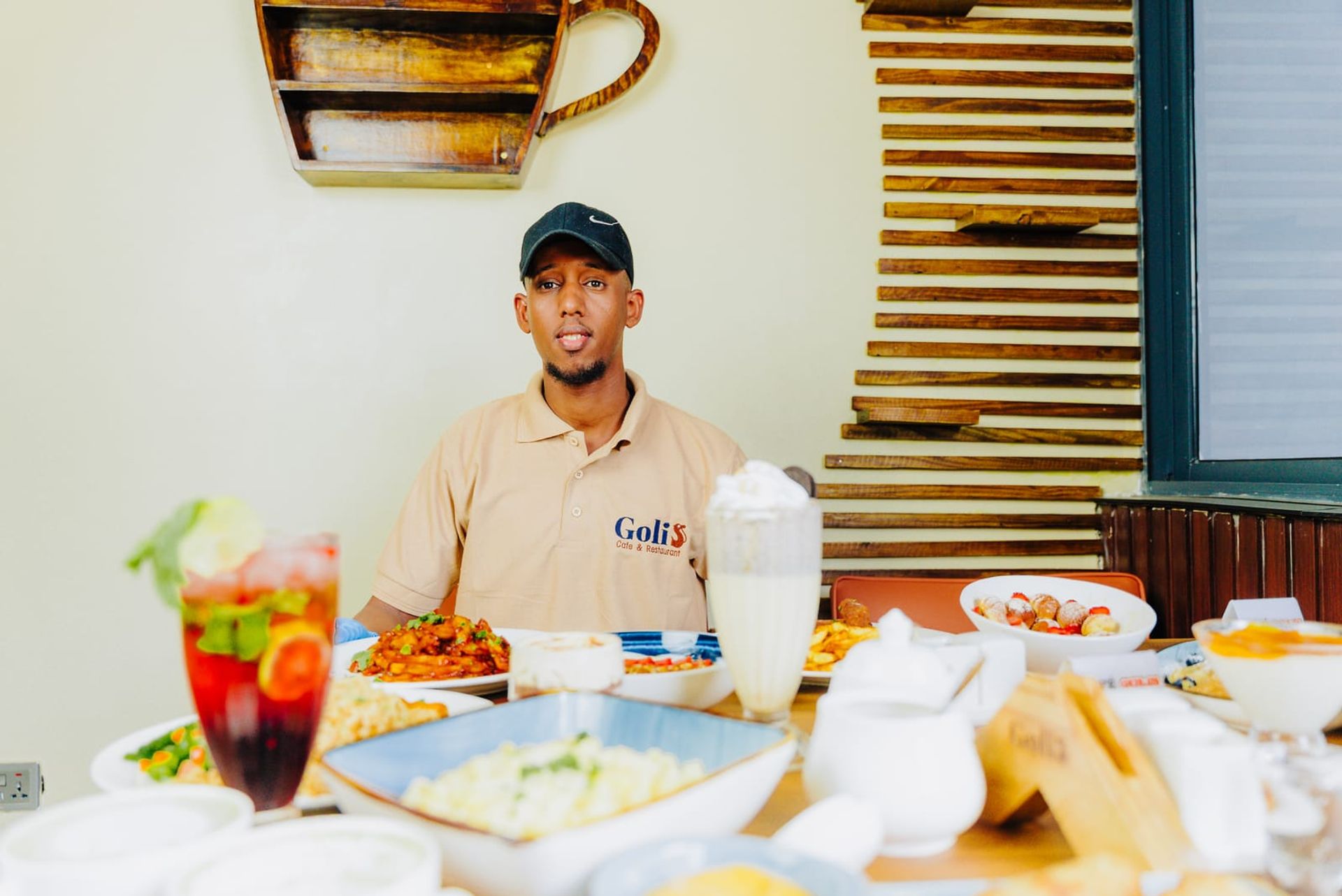 A table at Café Golis crowded with dishes and drinks, with the café’s wood-slat wall behind
